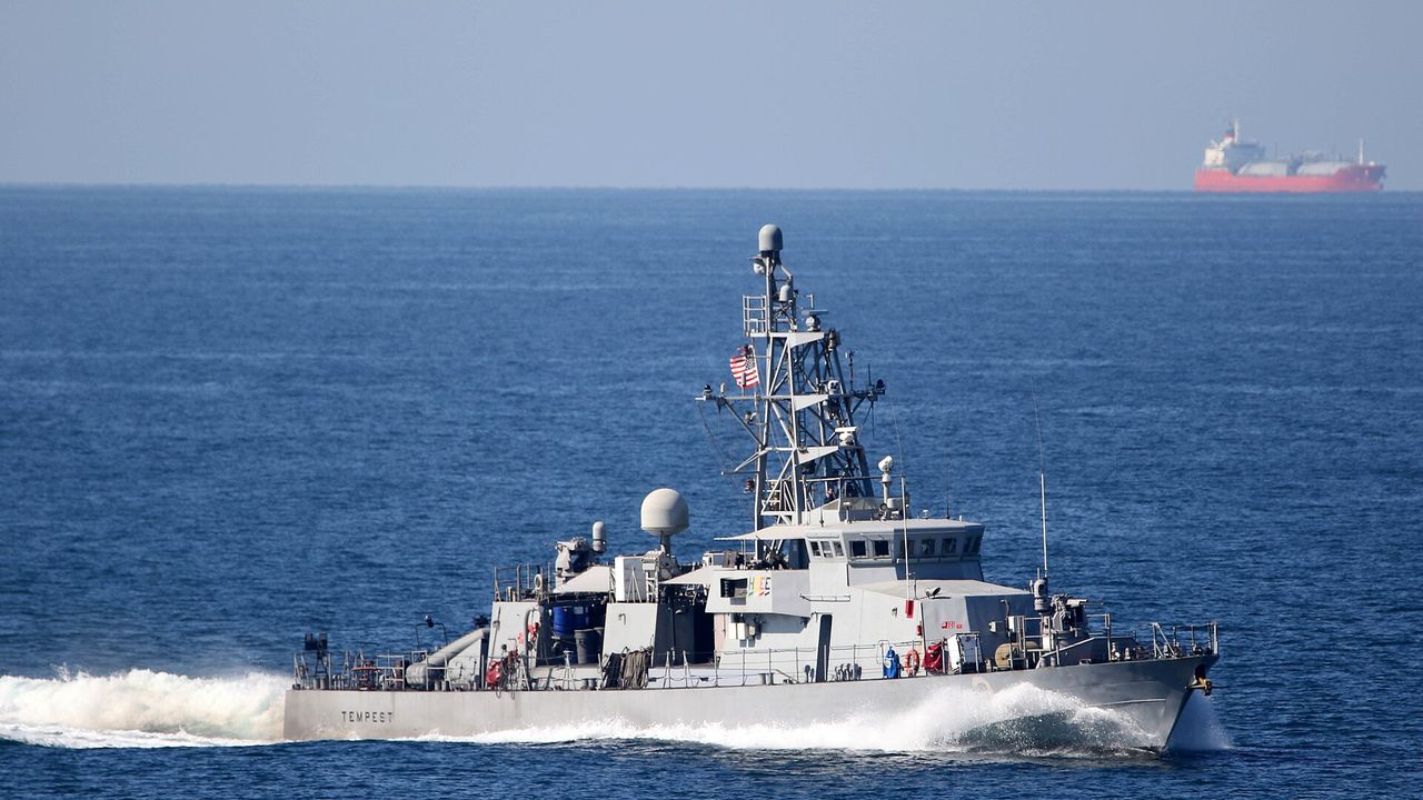美國海軍巡邏艦通過荷姆茲海峽，後方為油輪